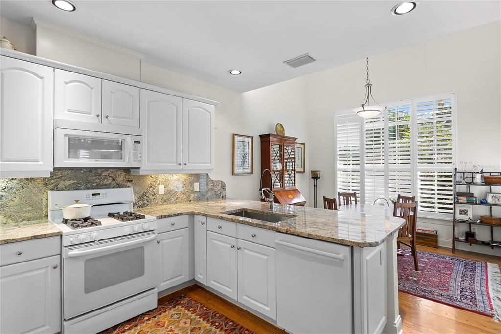 The kitchen includes gas cooking, loads of cabinetry and a wet bar and eat-in space with high ceilings