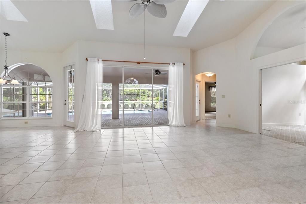 Living Room w/ Vaulted Ceilings, Ceramic Tile Floor, Skylights & 3 Panel Stacking Slider