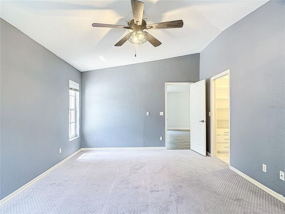 Master bedroom with vaulted ceilings, and ceiling fan.