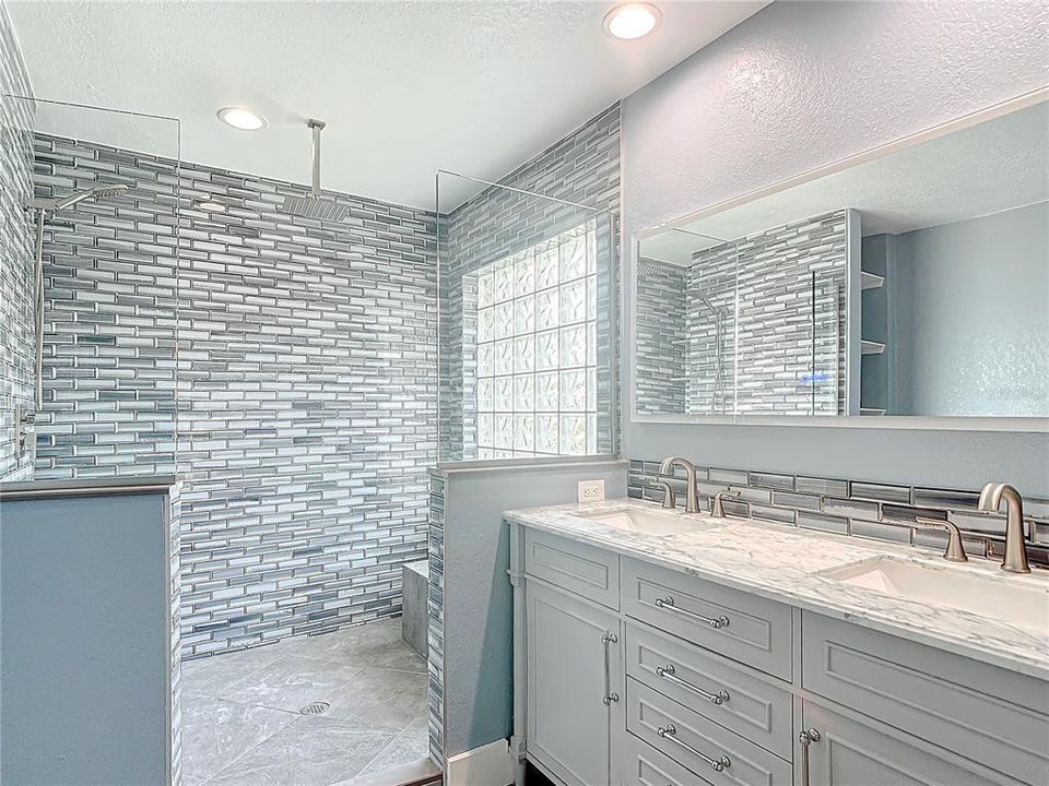 Amazing Master bath with beautiful tile and floors and it even has a smart mirror.