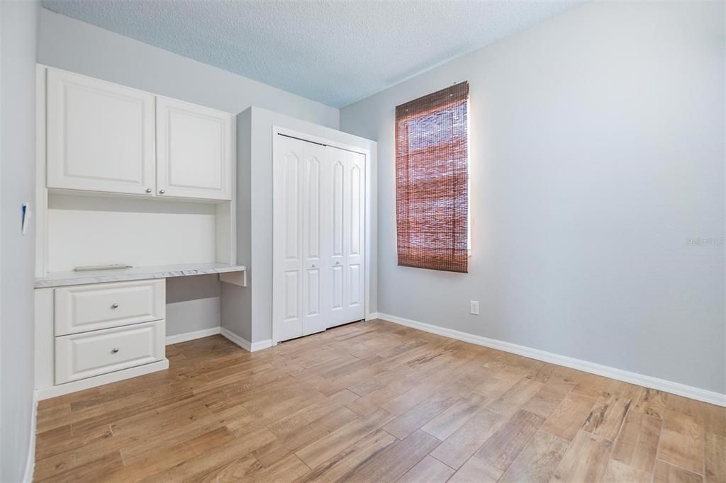 Guest Bedroom with wood floors and desk built in.