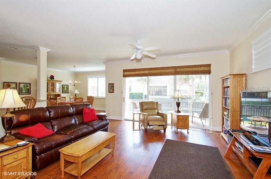 Spacious great room, opening onto covered patio and overlooking pond.  Breakfast bar is behind sofa at far left, and dining room is left center.