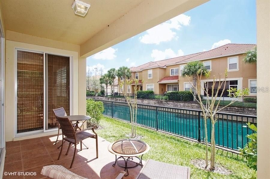 Finish your day with a cold beverage on this covered lanai with such a peaceful pond view.