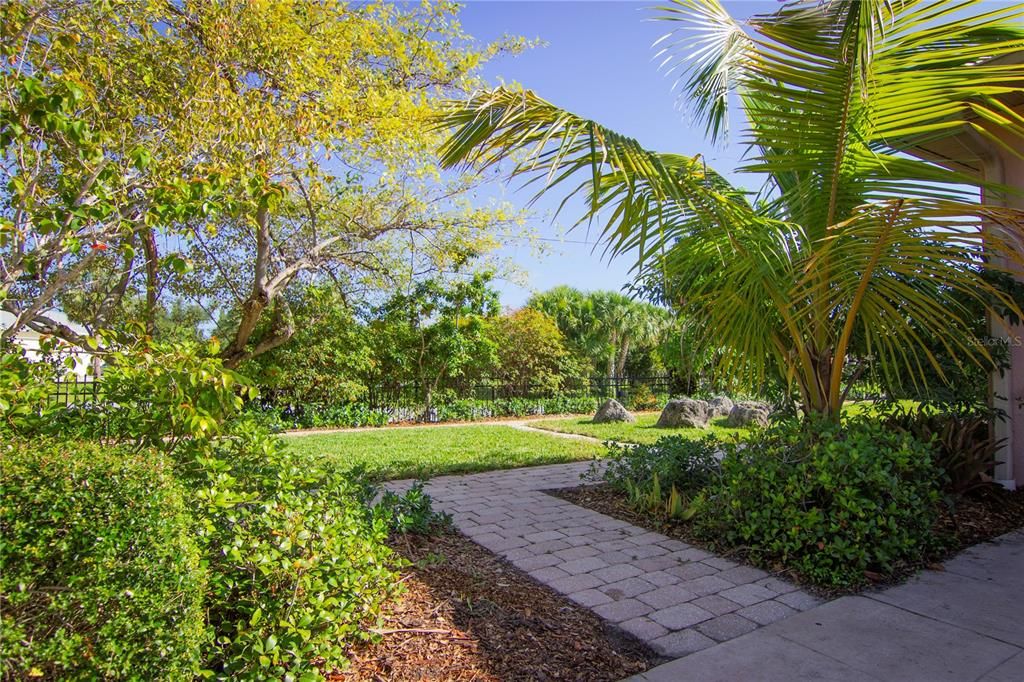 Paved, accessible walkways throughout the garden with privacy hedge. Fruit trees are seamlessly integrated into the Florida-friendly garden design.