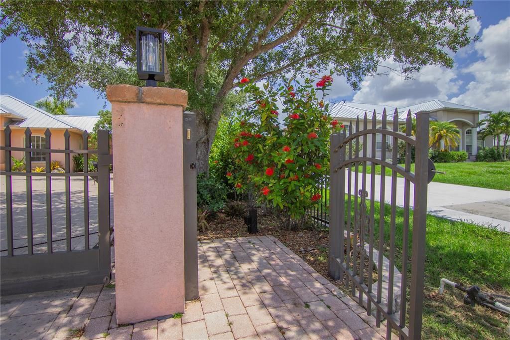 Driveway with motorized gate entrance and pedestrian gate.