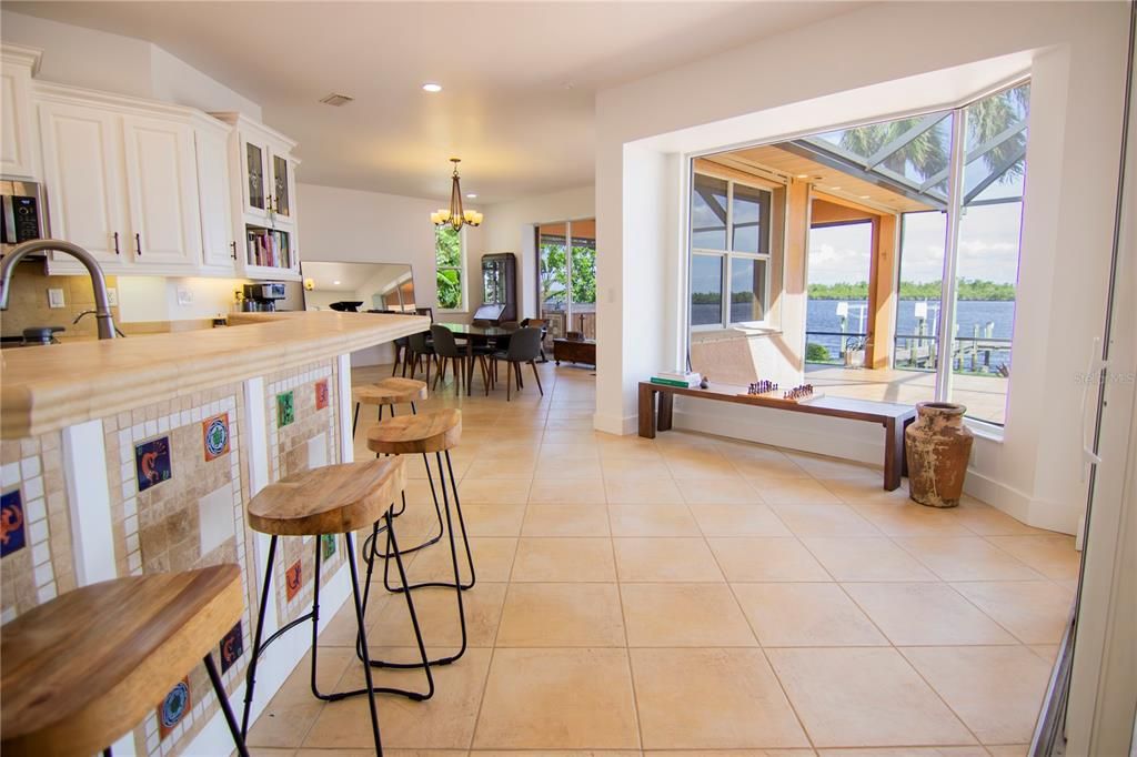 Open floor plan breakfast bar and nook with picture window with views of the pool, the garden, and Peace River