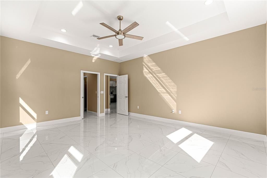 PRIMARY SUITE WITH TRAY CEILING WITH PLENTY OF LIGHTING AND CEILING FAN