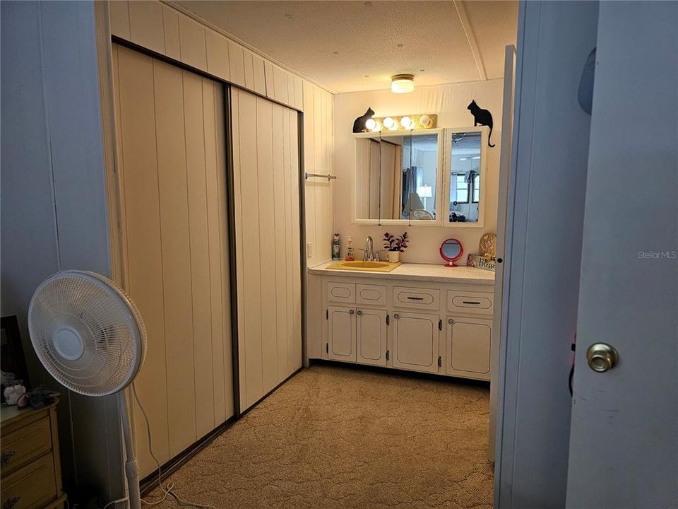 The sink is outside of the restroom and has plenty of cabinets space