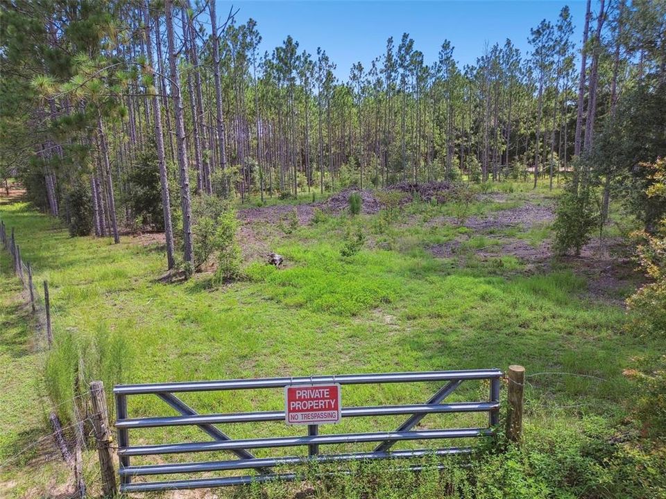 Separate entrance. Semie-cleared area is where the home ideally would go. Electric pole located to the right of the fence.