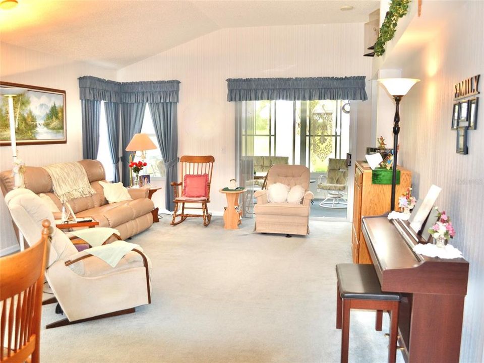 Living room with Energy efficient ceilings leads to enclosed lanai.