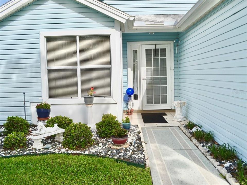 Inviting entry. Easy care shrubs, tiled stoop, screened/glass storm door.