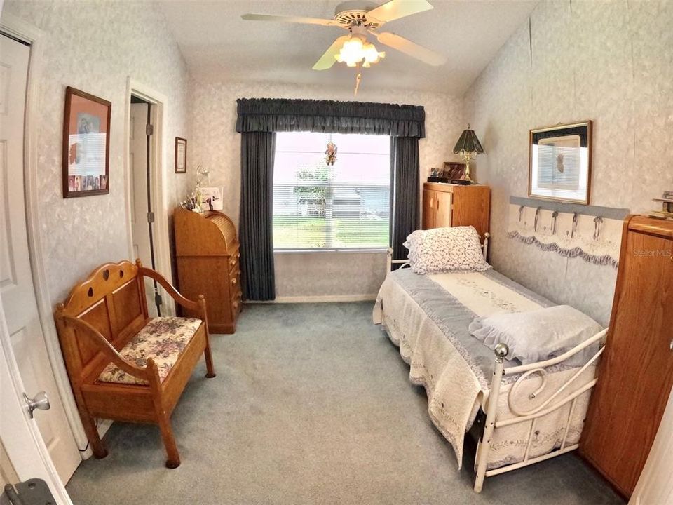 Guest BR, cheery with trundle bed. Built in closet. Overhead cabinetry unseen.