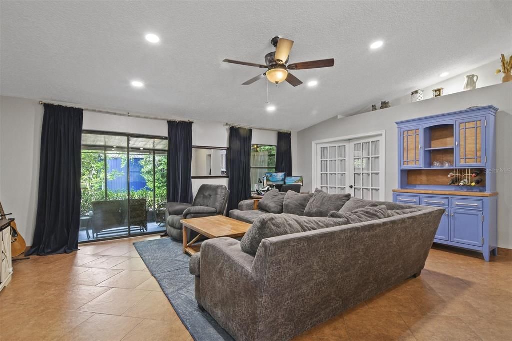 The light and bright OPEN CONCEPT living area features low maintenance TILE FLOORS set on a diagonal, VAULTED CEILING and the large SLIDING GLASS DOORS not only give you access to the SCREENED LANAI but lets the natural light pour in.