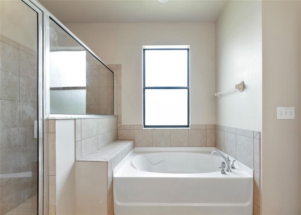 Primary en suite with garden tub, walk-in shower, dual vanities, water closet