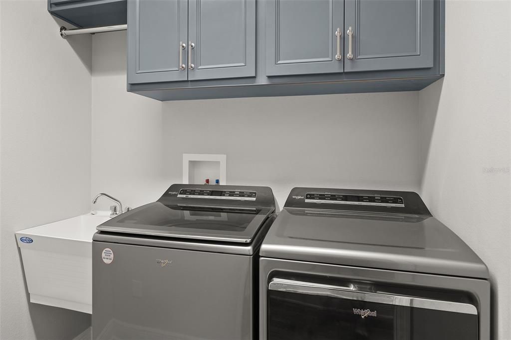 Laundry With Extra Storage Cabinets and Set Sink.