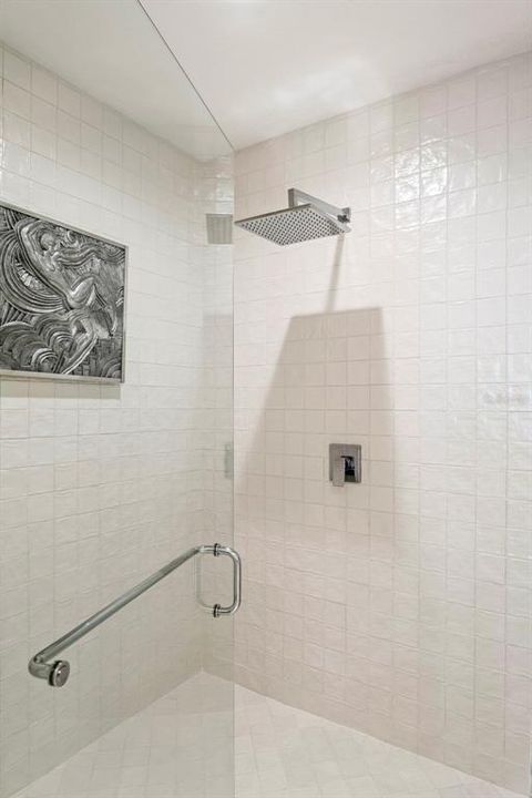 The glass and tile surround shower with rain head.