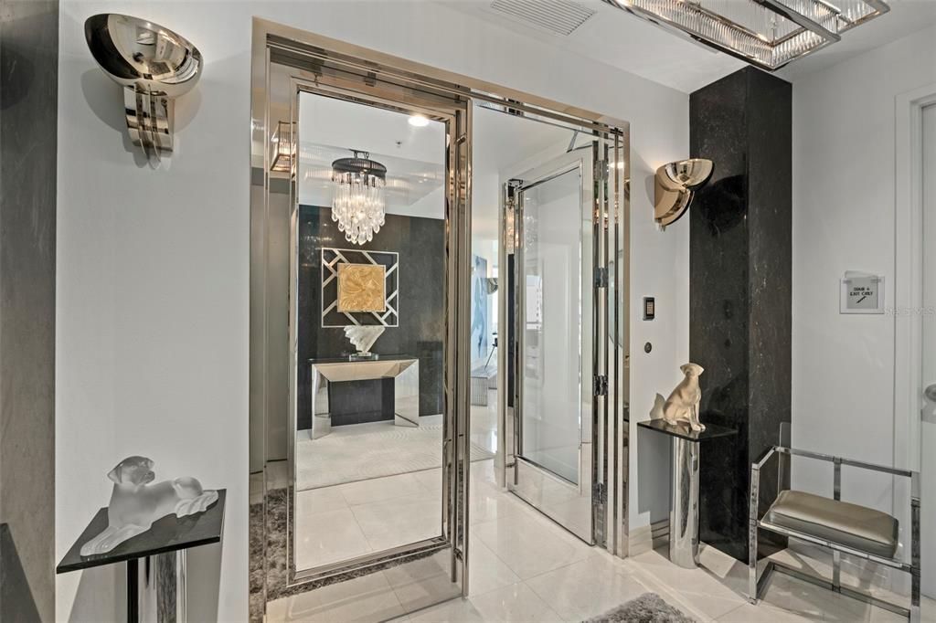 The private entry is adorned with marble columns, white marble floors, and chrome and glass inlay doors.