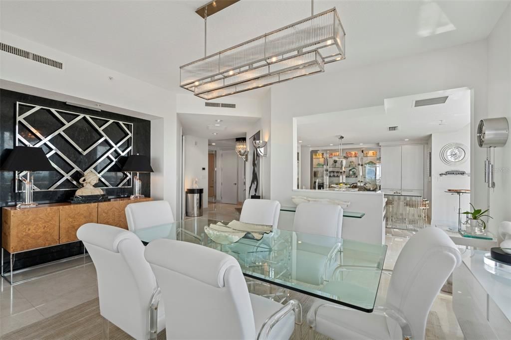 The dining room features a black marble accent wall and designer lighting