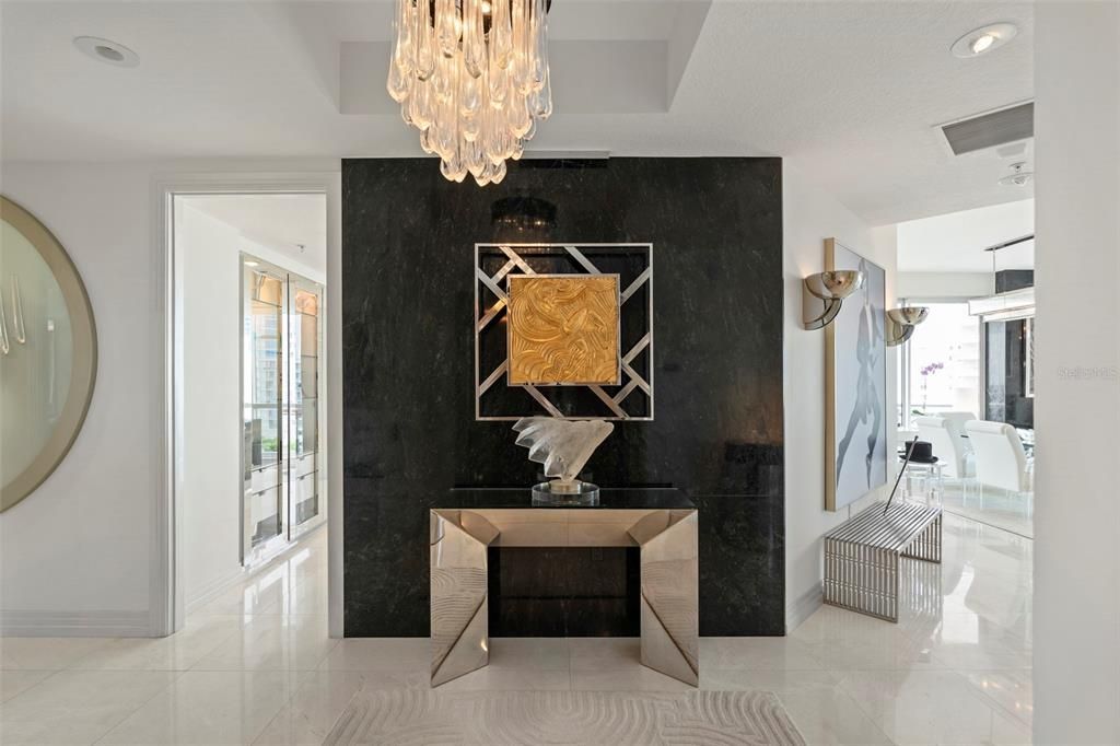 The private entry adorned with white marble floors and chic black marble accent walls.