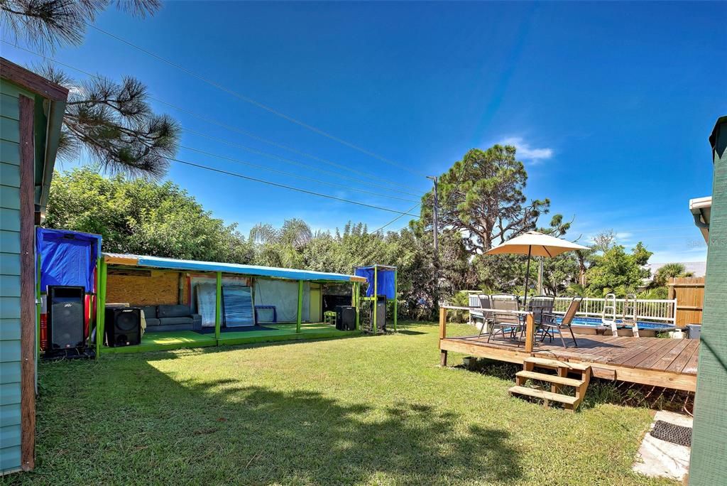 Very large backyard contains a shed, a deck, above ground swimming pool and a covered structure to use as you would like - tiki bar, outdoor dining or stage a concert.