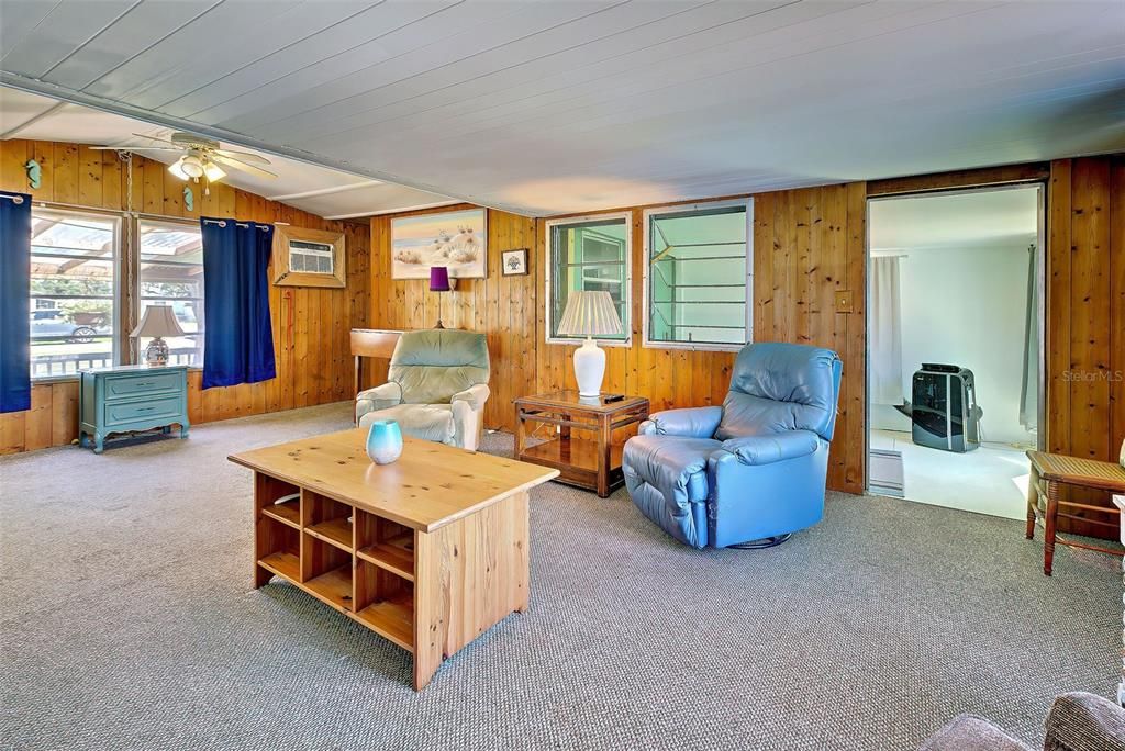 The knotty pine covered walls add to the overall character of this open.  The living room opens to the bonus room.