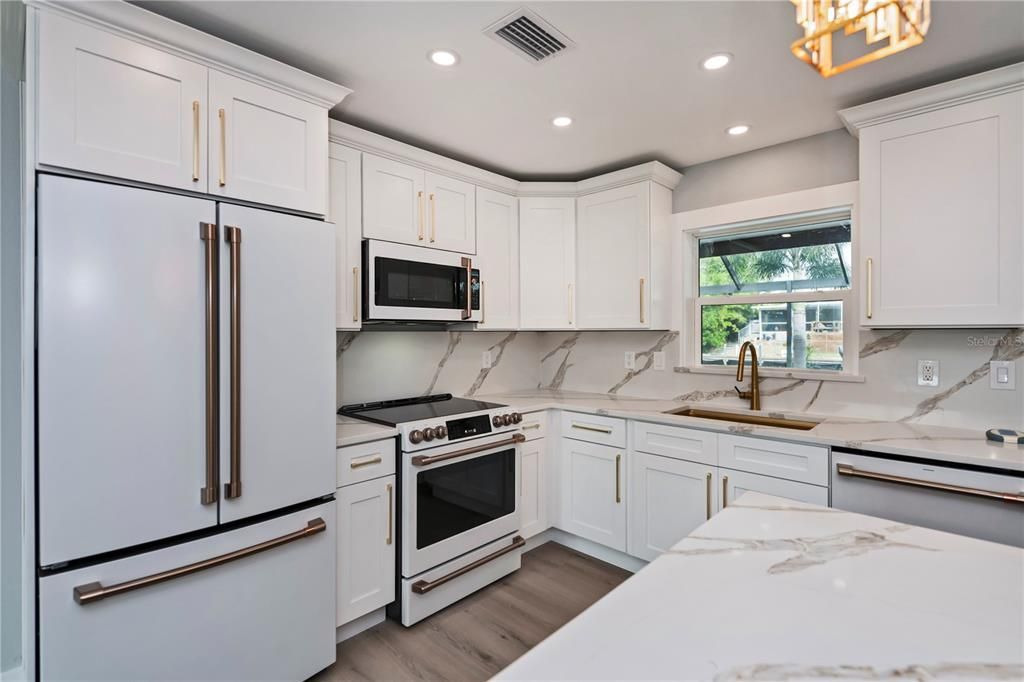 Quartz countertops and matching backsplash with coordinating island, premium appliances