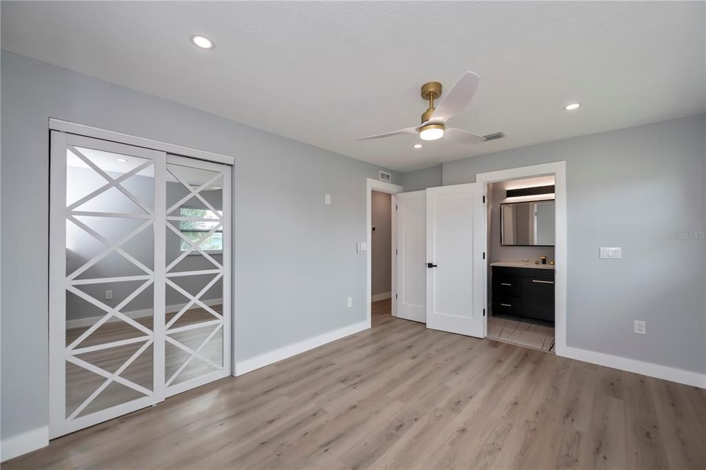 master bedroom with decorator mirrored slider closet, fan and ensuite bath too is spacious