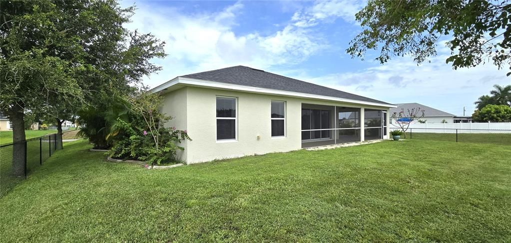 Rear view of home from fenced backyard