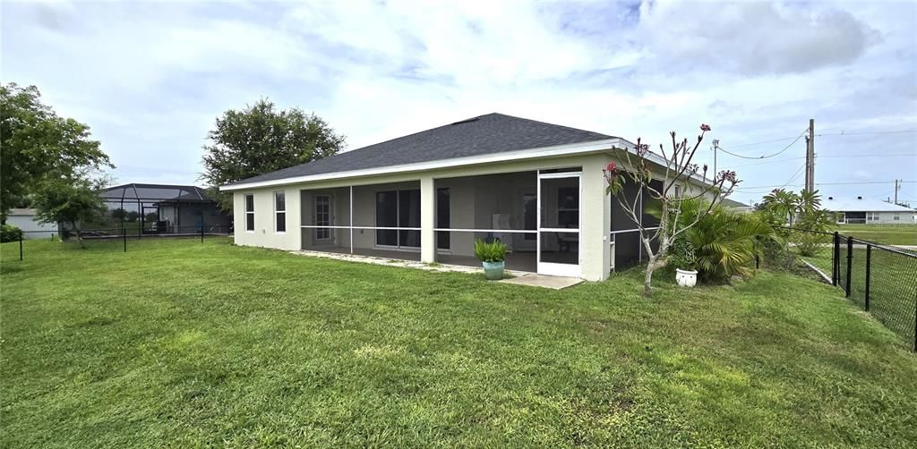 Rear view of home from fenced backyard