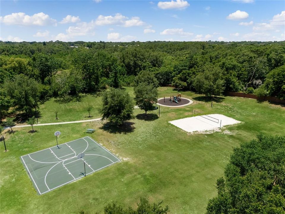 Park with sand volleyball, playground, and basketball court