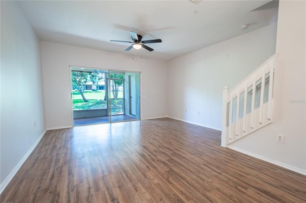 The living room and dining rooms feature neutral tone walls and wood laminate flooring.