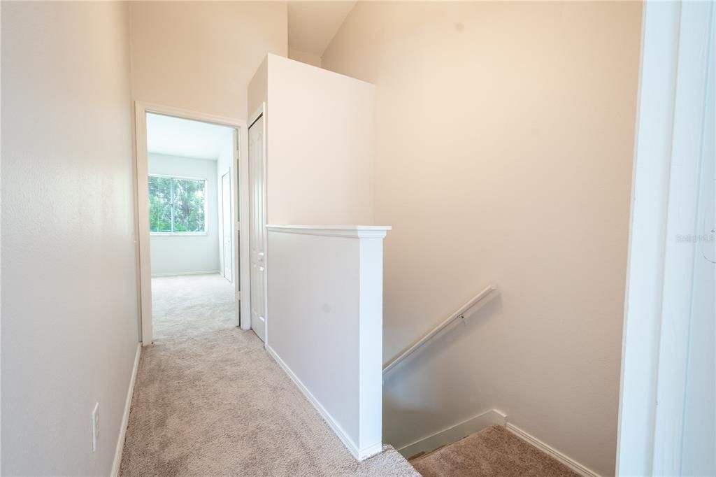 The 2nd floor hallway features carpeted floor and linen closet.