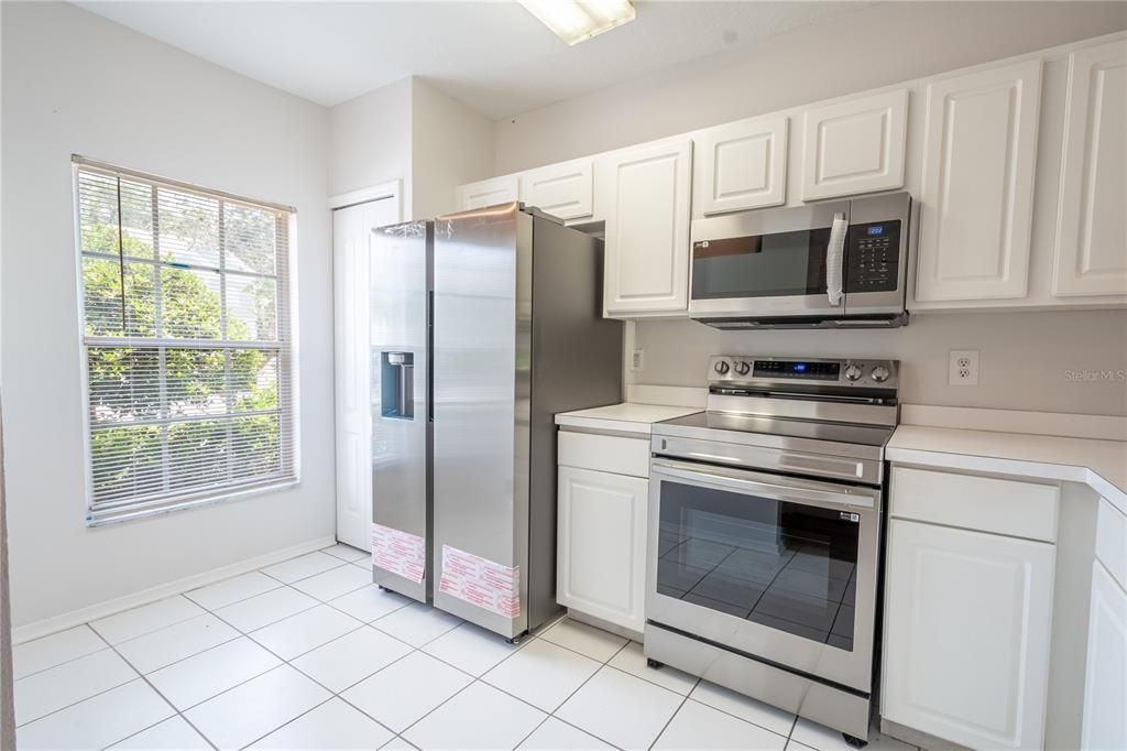 The kitchen features plenty of natural light, a ceramic tile floor and stainless steel appliances including a range, microwave and French door refrigerator with water dispenser.