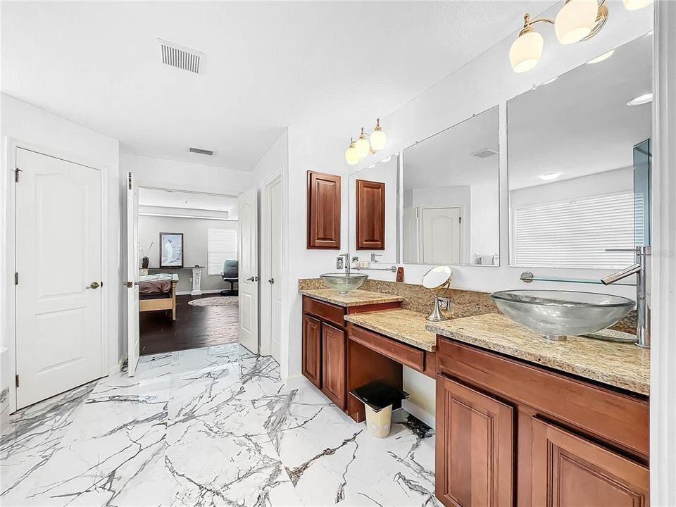 The master bathroom has been remodeled with European flair. Dual sinks with granite counters.  Mosaic flooring and tile in the bathroom. There are also two extra large walk-in closets.