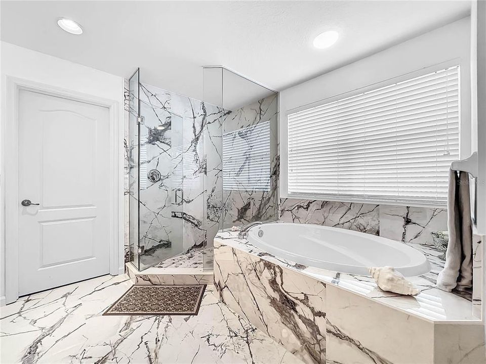 The master bathroom has been remodeled with European flair. Dual sinks with granite counters.  Mosaic flooring and tile in the bathroom. There are also two extra large walk-in closets.