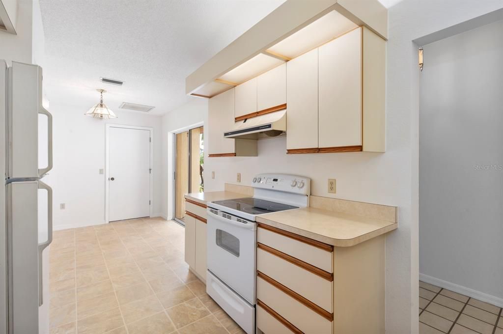 Spacious kitchen includes closet pantry, natural light from sliders and high ceilings! Convenient entry from garage!