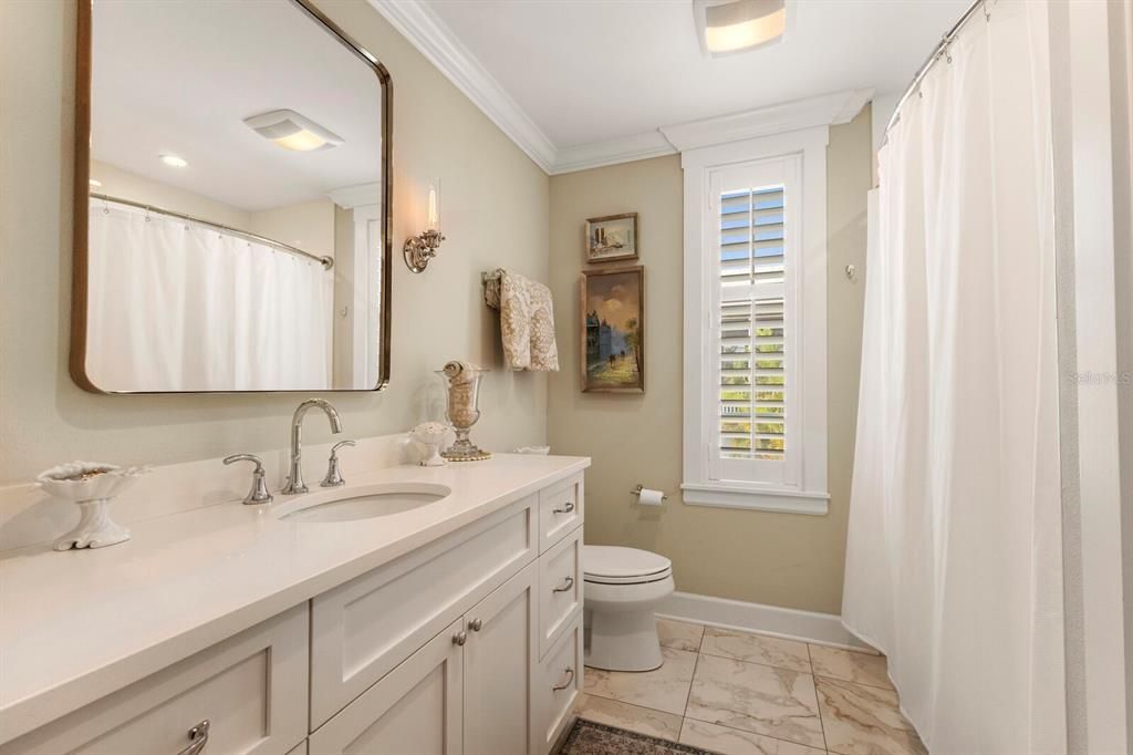 bathroom 2 - stone counters, tub/shower combo, linen closet, plantation shutter