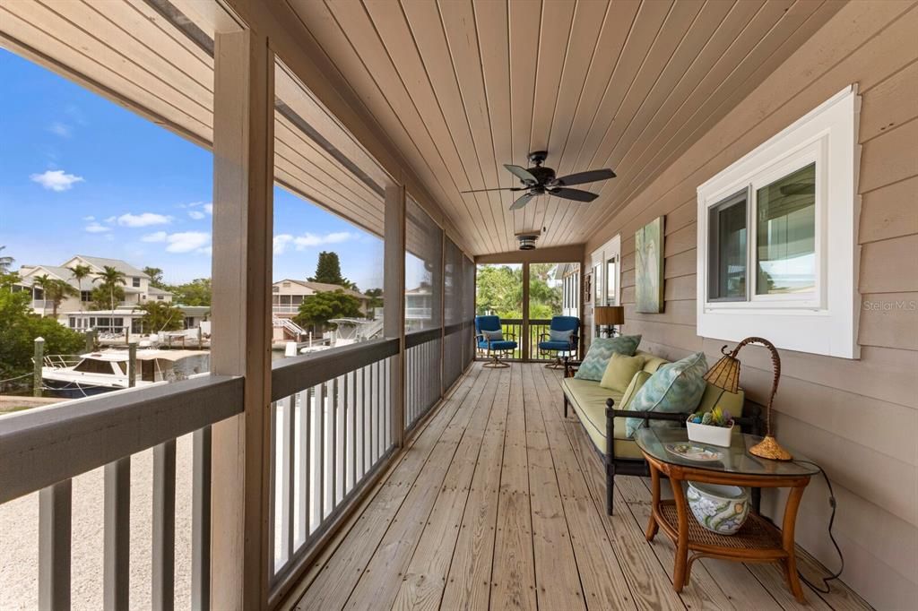 Large screened-in covered patio w/ fans off of the main living area - views of the water too!