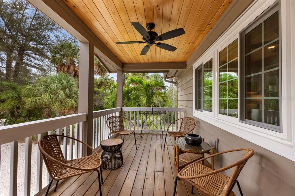 front covered porch w/ fan, wood ceiling and views of the Bay