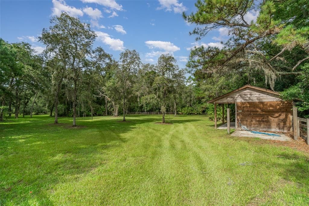 This fenced pasture and stable with stalls is located to the left (west) of the house