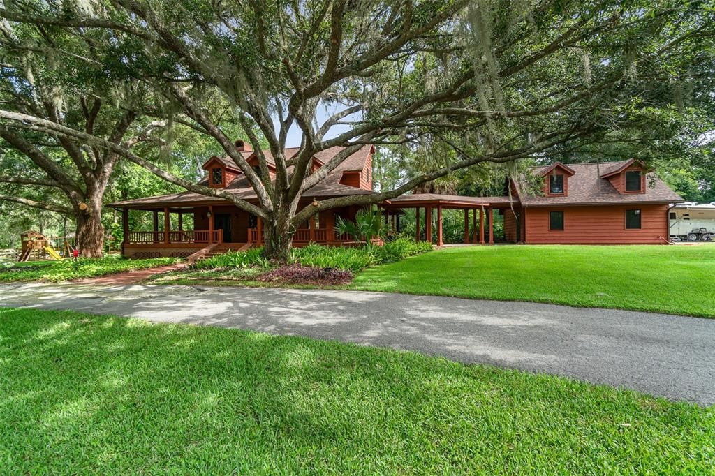 Front Elevation with massive twin oaks flanking the front of the Home