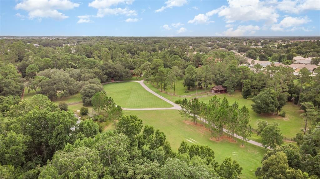 Aerial view of the front of the property.  Note the outbuilding with stalls to the right of the driveway