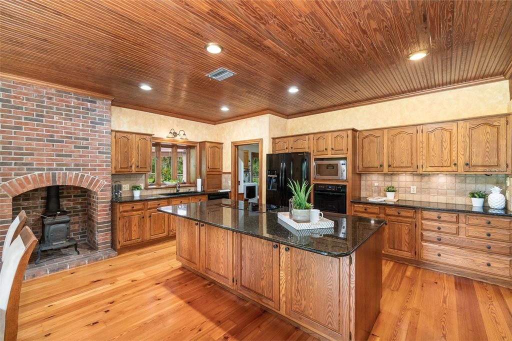 Kitchen with center island and cook top with firelplace and wood stove to the left