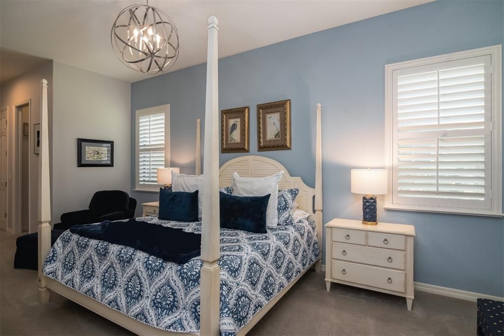 The large master bedroom has designer lighting fixtures, split windows with plantation shutters and quality carpeting.