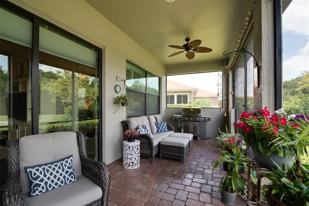 The covered and screened lanai has ceiling fans and gloss sealed paver flooring.