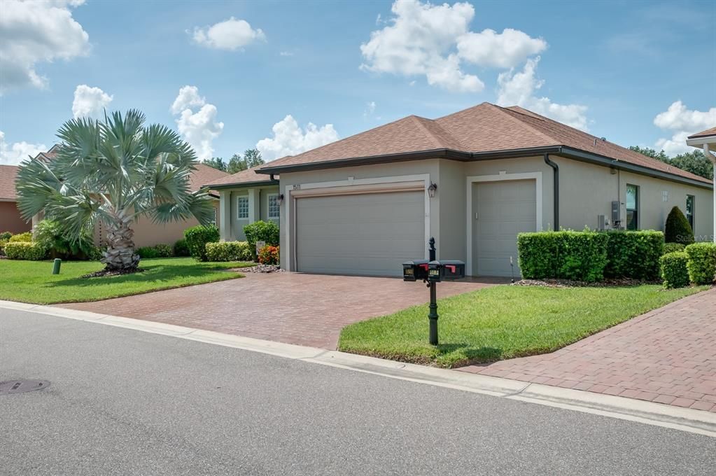 The attached 2 car with golf cart garage has a remote-controlled roll up garage screen system.