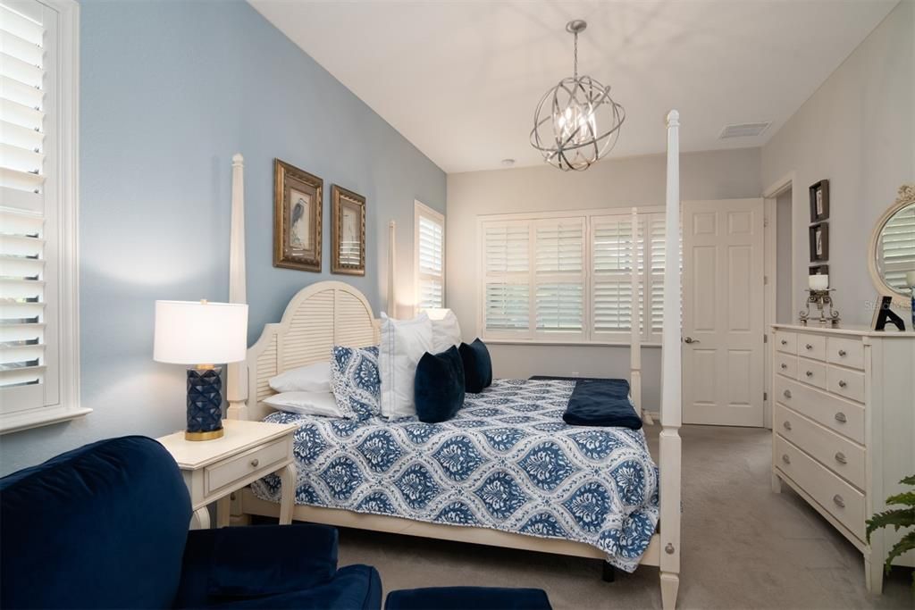 The primary bedroom has a large window area with plantation shutters that look out to the pond and preserve.