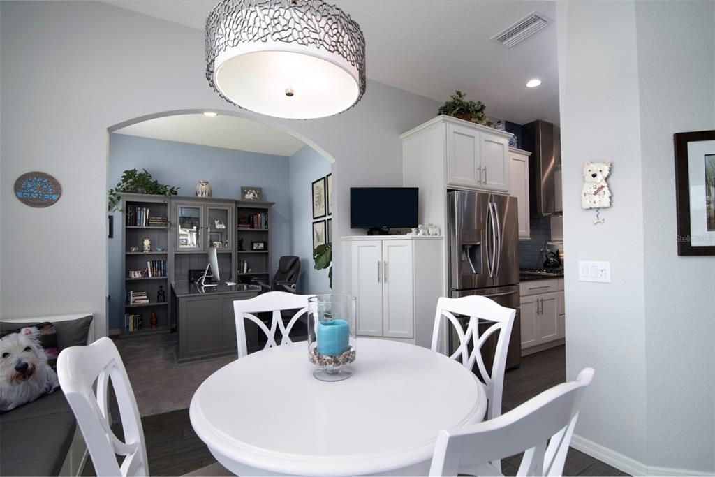 The custom lighting fixtures and wood look ceramic tile flooring are elements of the dinette.