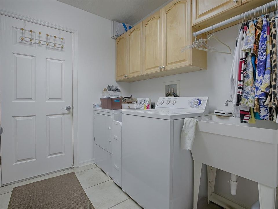 LAUNDRY ROOM WITH TUB SINK, CABINETS AND SHELVING