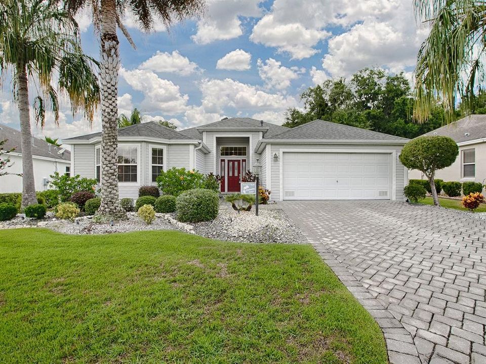 BEAUTIFUL LANDSCAPING,  A PAVERED DRIVEWAY AND A RED DOOR WITH LEADED GLASS MAKE FOR A GRAND ENTRANCE!